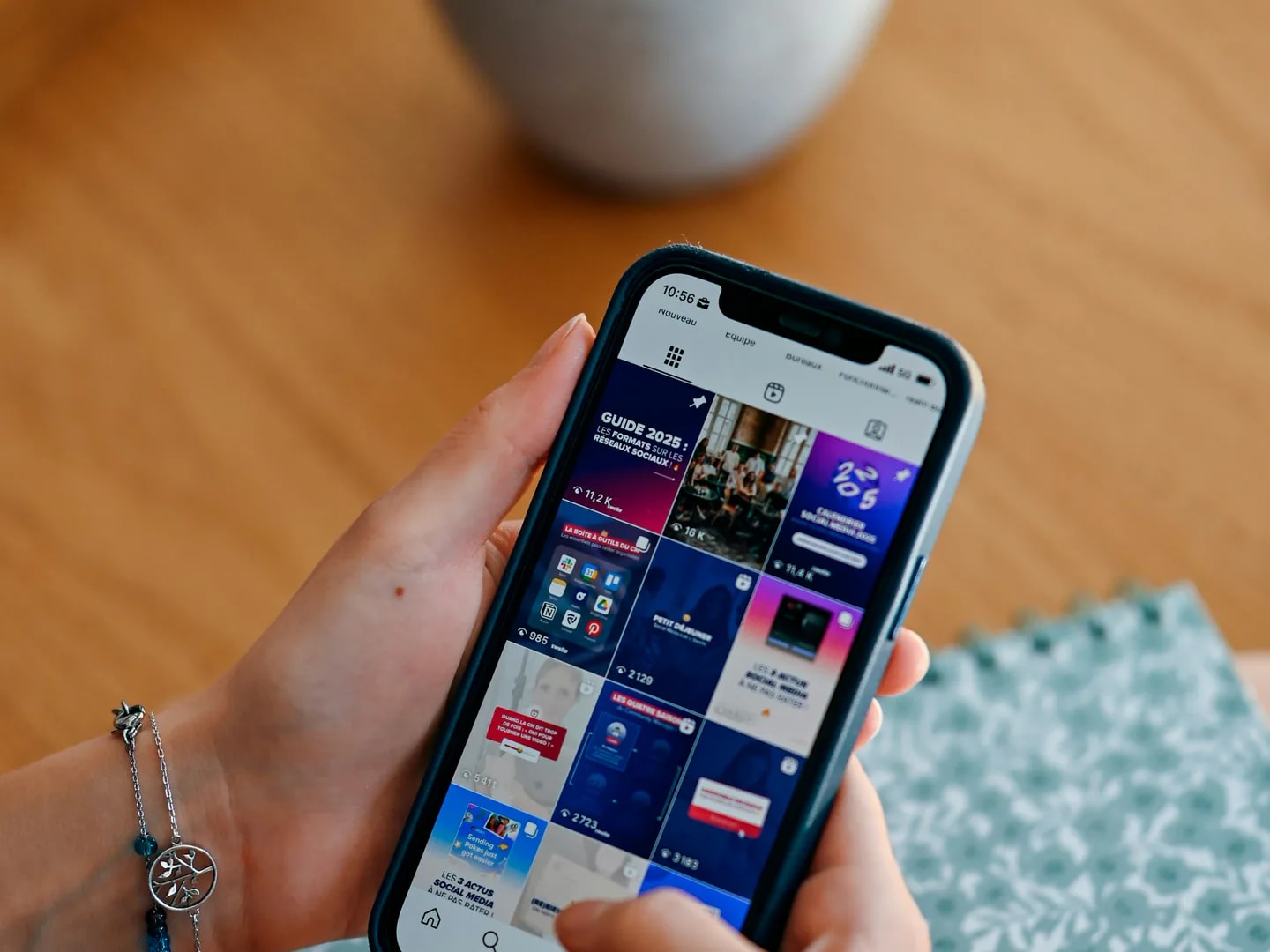 A phone displaying a grid of social media posts