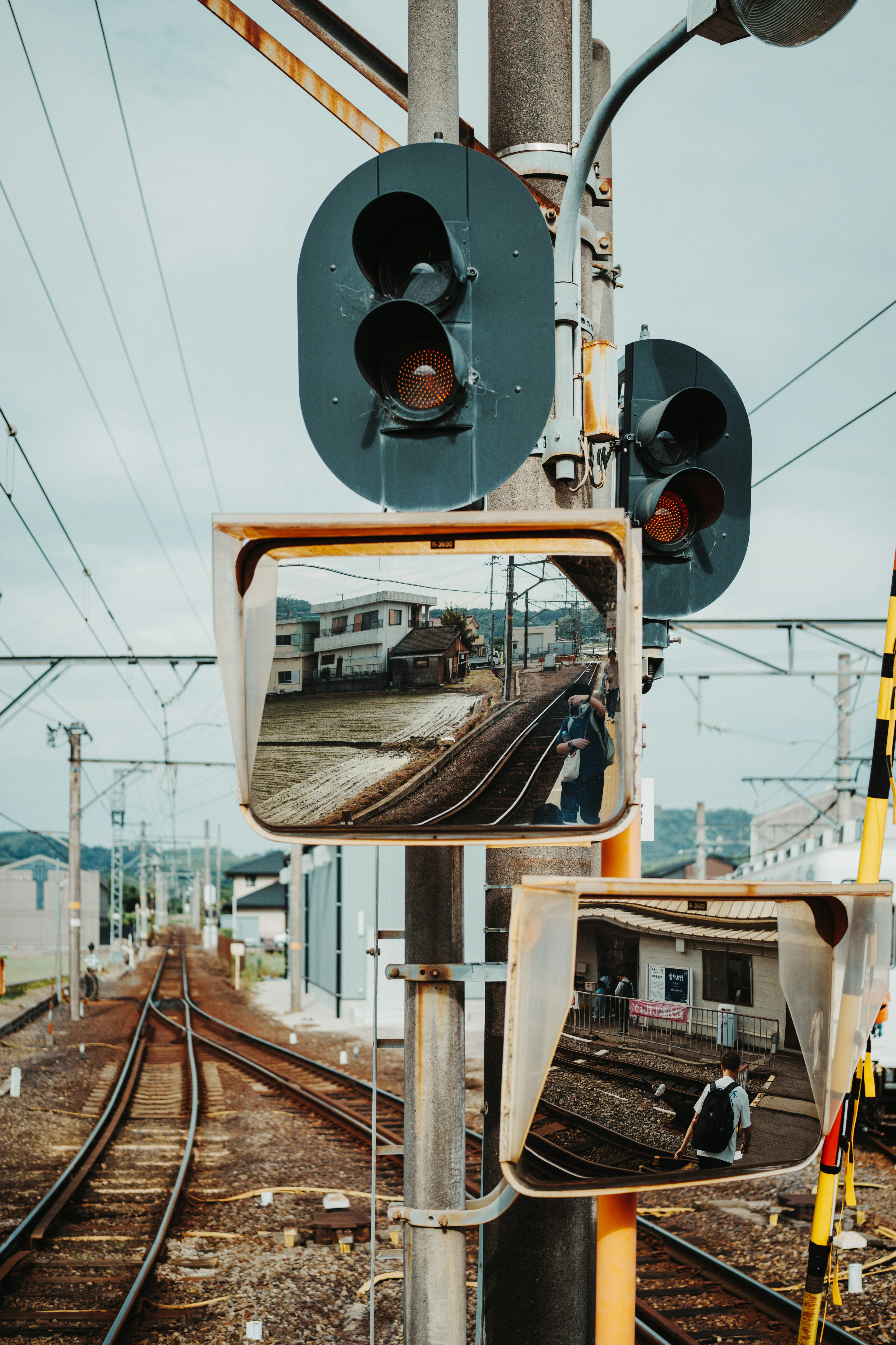Train tracks reflected in safety mirrors with signals