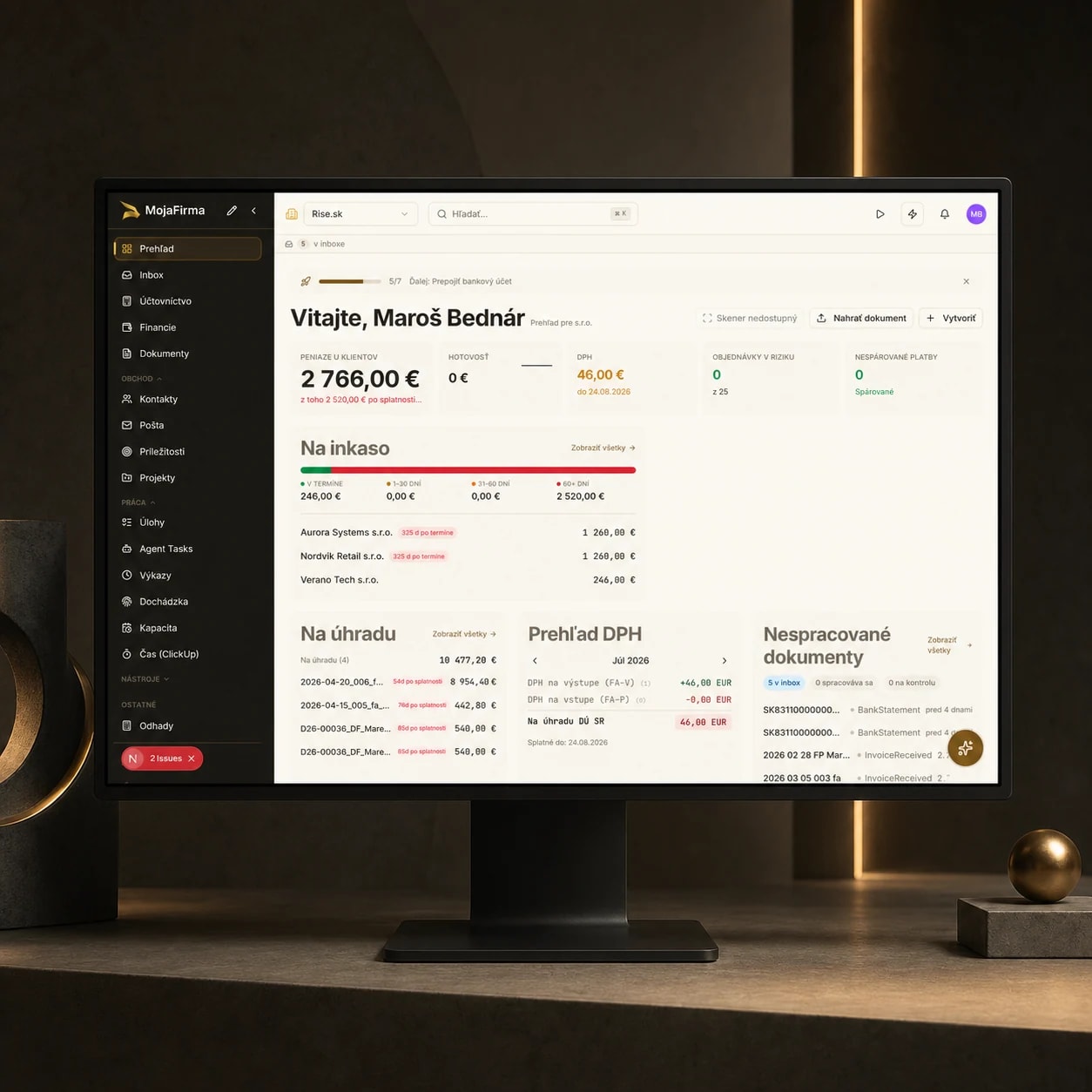 MojaFirma finance overview with AI agents on a desktop monitor